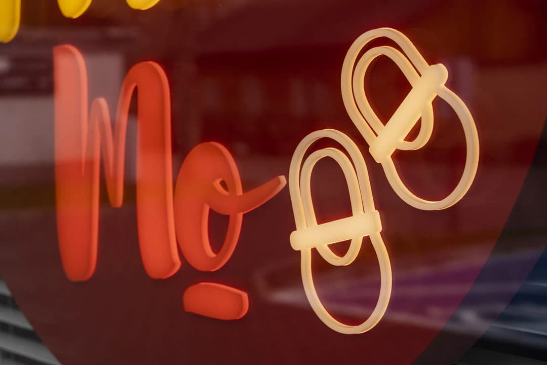 boutique, cercueil illuminé, derrière une vitre jaune et rouge.